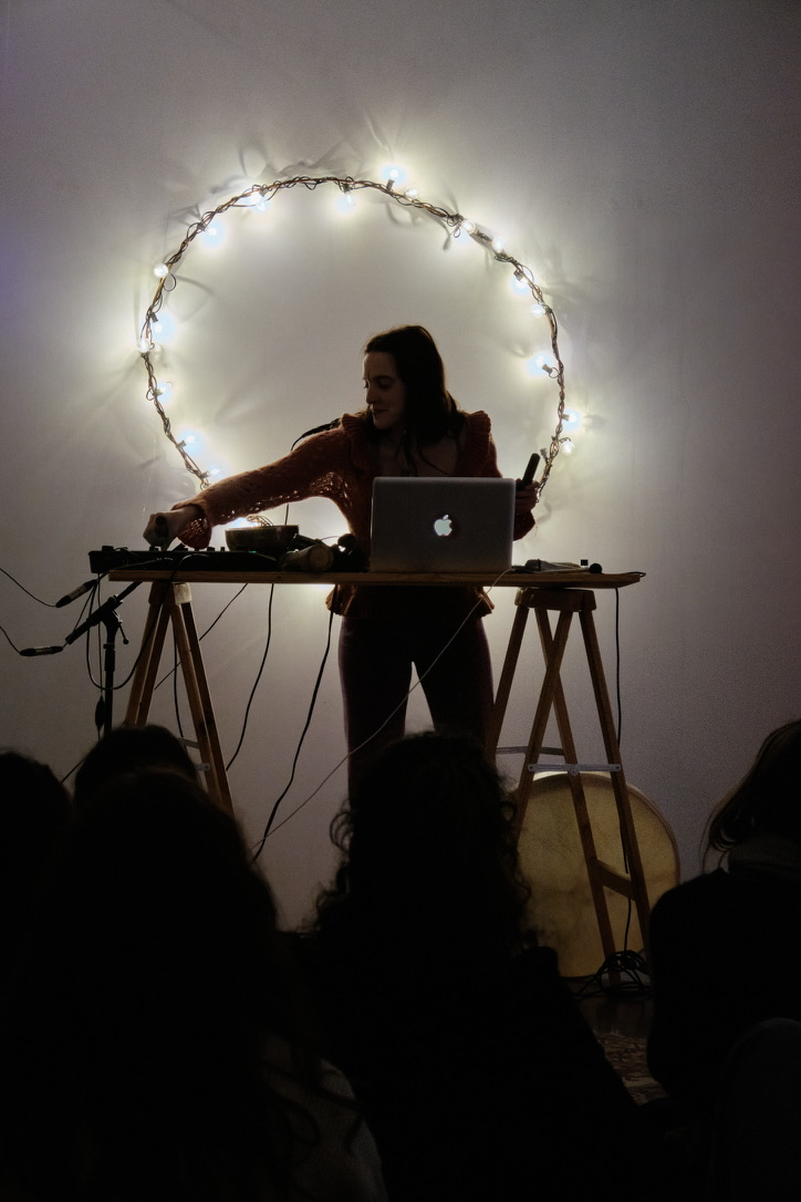 Nina en DJ set sous une auréole lumineuse — voyage sonore intimiste
